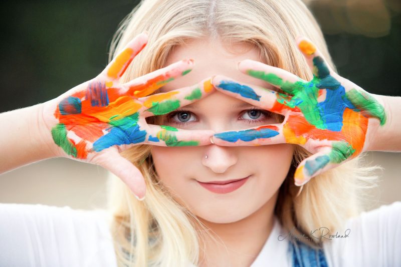 high school senior portrait with paint on hands