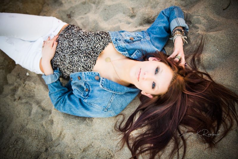 High school senior portrait Of senior girl laying on beach