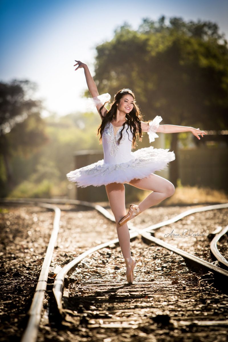 High school senior portrait of ballerina on train tracks
