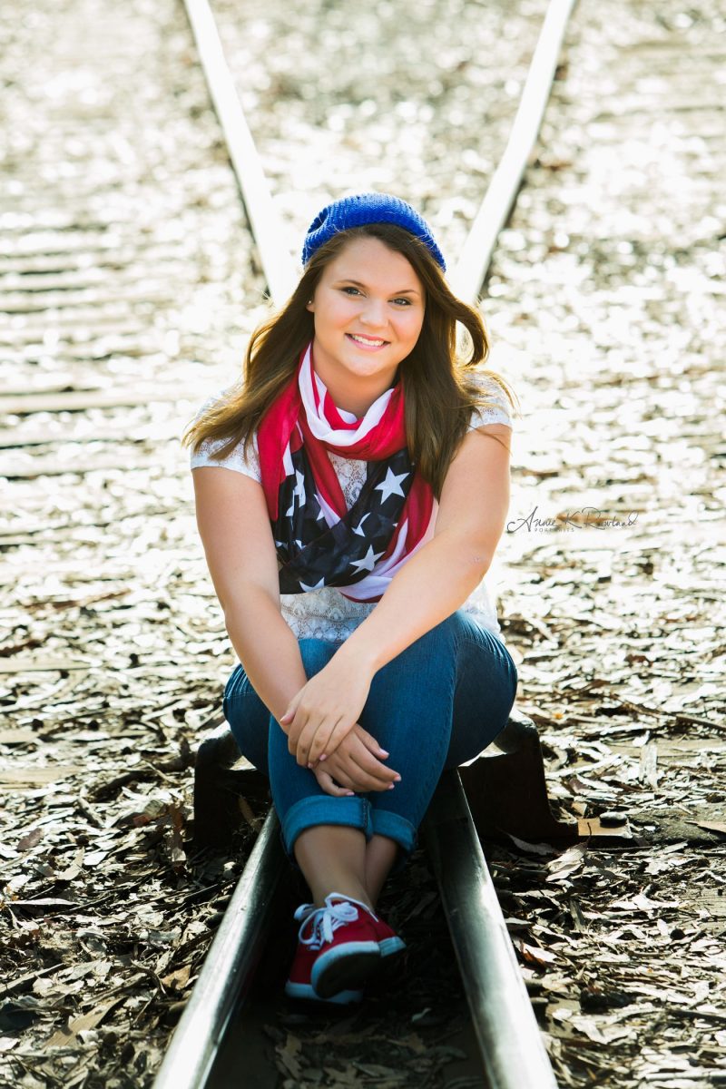 High school senior portrait of senior girl on train tracks