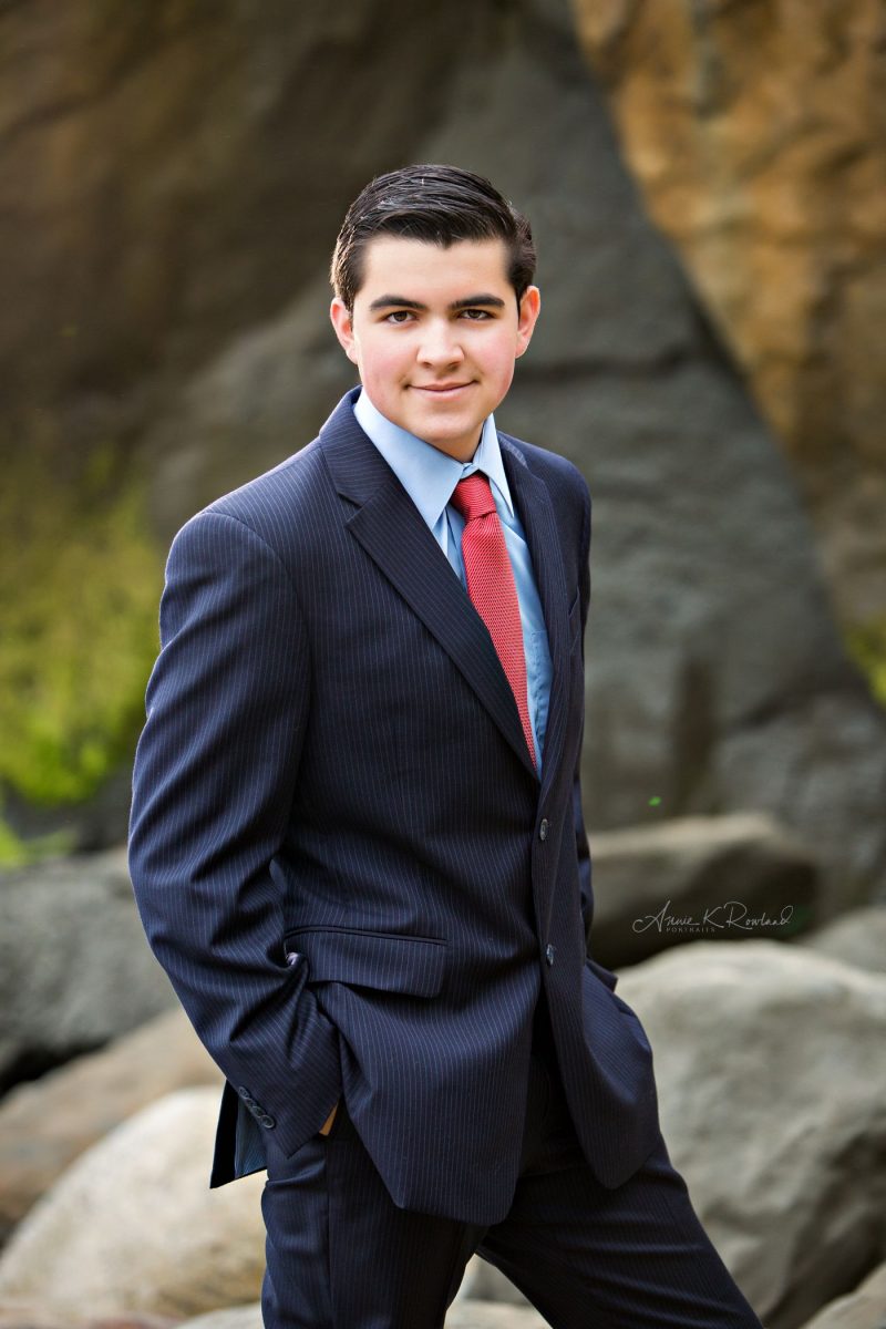 High school senior portrait of senior boy in suit on beach